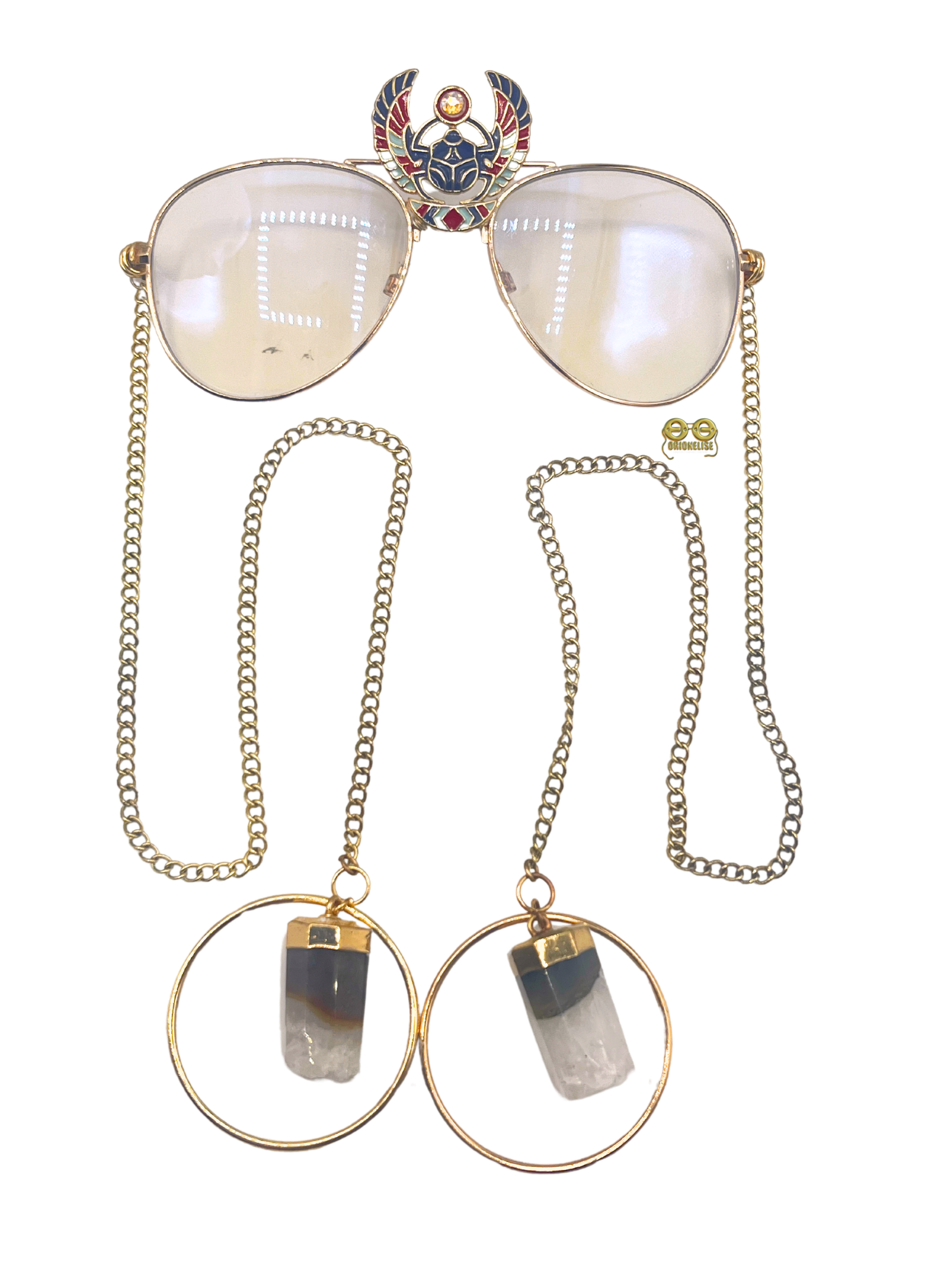 Luxor fashion glasses by Orion Elise. Handcrafted gold-framed glasses with chain arms and scarab design. Genuine quartz stone embellishment adds mystique and allure. Symbol of power, confidence, and individuality. Perfect for red carpet events, high-profile gatherings, or casual nights out. An Erykah Badu vibe for certain. Join the ranks of style icons and express your individuality with Luxor.