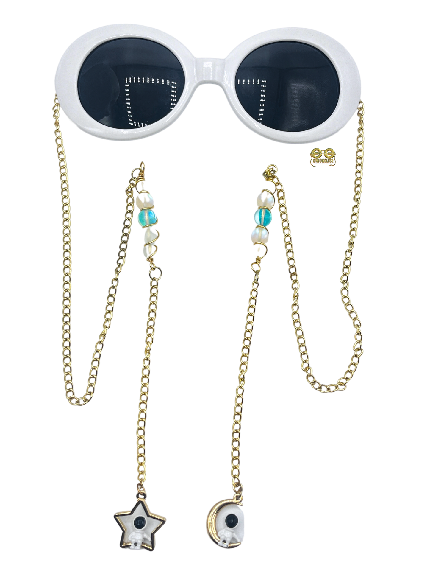"Spaced Out" fashion eyewear by Orion Elise. Gold chain arms with glass bead and wire entanglement. Metal moon and star charms with astronauts, evoking a cosmic journey. Embrace your inner astronaut and reach for the stars with "Spaced Out." 